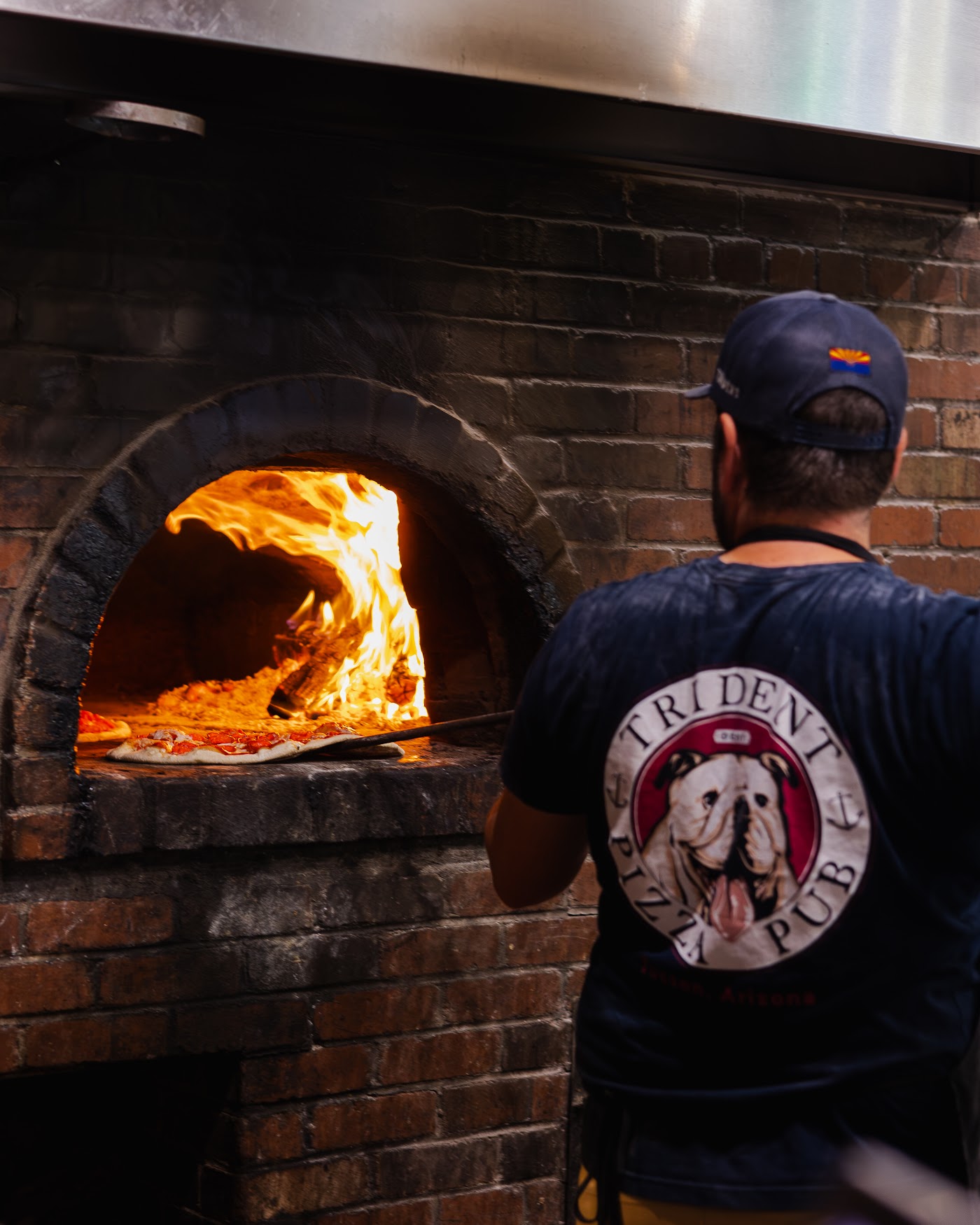 Pizza going into the wood-fired oven