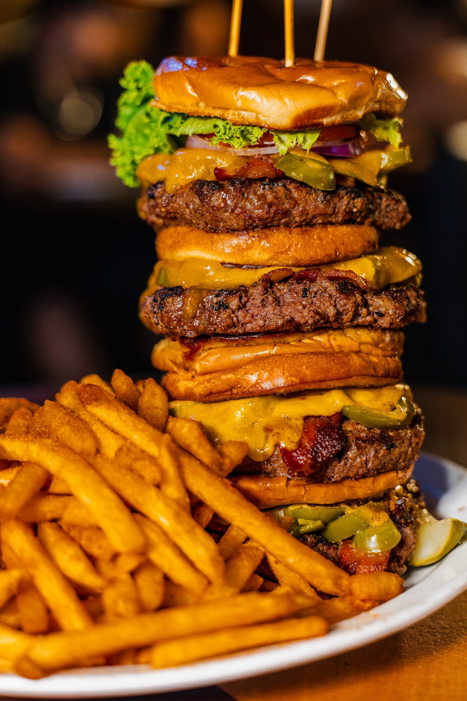 The Navy SEAL burger: four stacked patties with jalapeños and a pile of fries